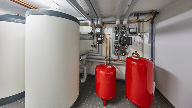 Effiziente Heiztechnik mit Warmwasserspeicher und intelligenter Regelung Heizungsraum mit modernen Pufferspeichern, Ausdehnungsgefäßen und Rohrsystem