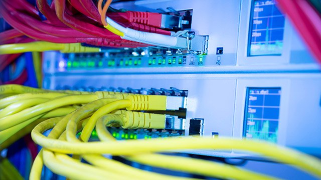 Strukturierte Gebäudeverkabelung und Datenvernetzung in der Elektrotechnik Netzwerk-Switch mit angeschlossenen Ethernet-Kabeln und Aktivitätsanzeigen