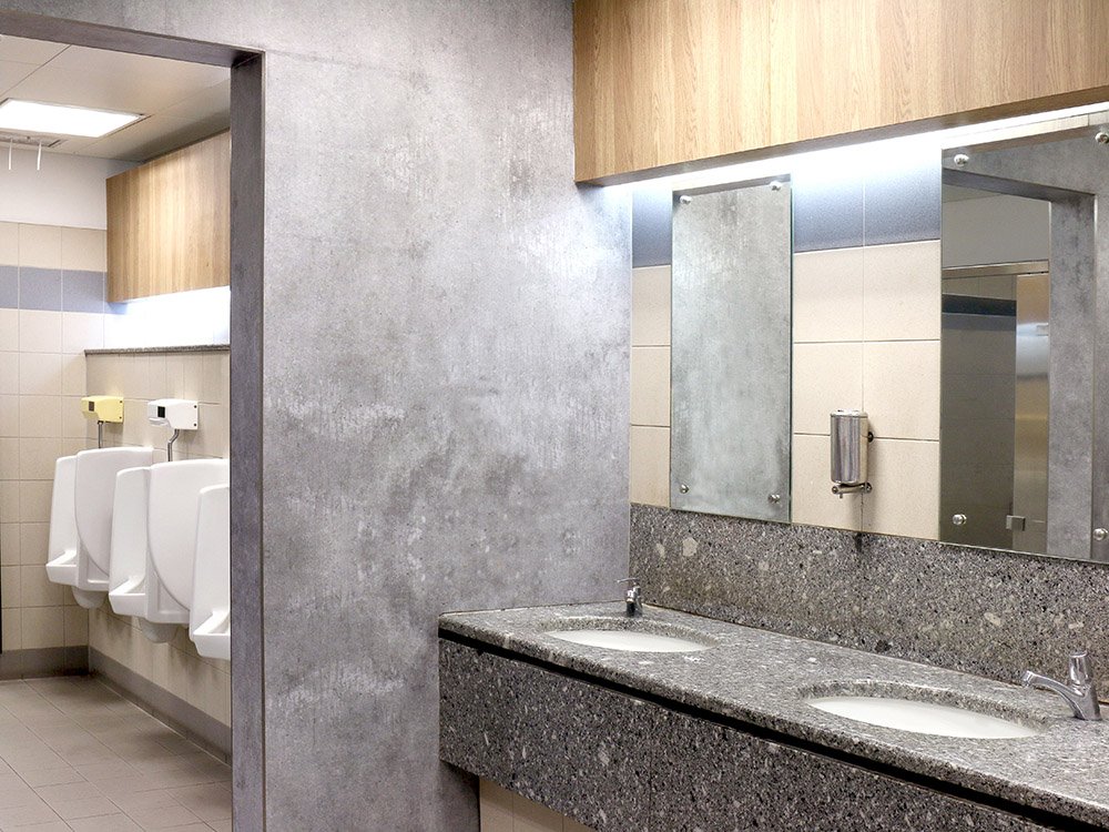 Moderne Sanitärinstallation in einem öffentlichen Waschraum mit funktionaler Ausstattung Öffentliche Sanitäreinrichtung mit Waschbecken, Spiegeln und Urinalen