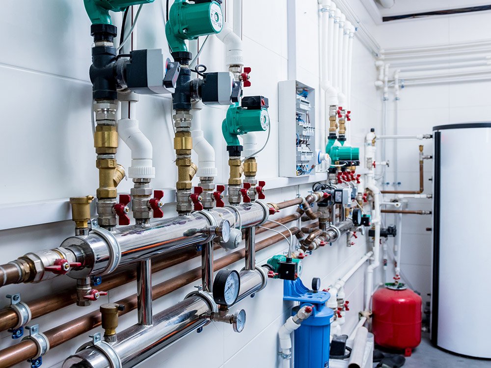 Heizungsanlage mit Rohrleitungen, Pumpen, Ventilen und Warmwasserspeicher Komplexe Heiztechnikinstallation mit moderner Steuerung und Energiemanagement