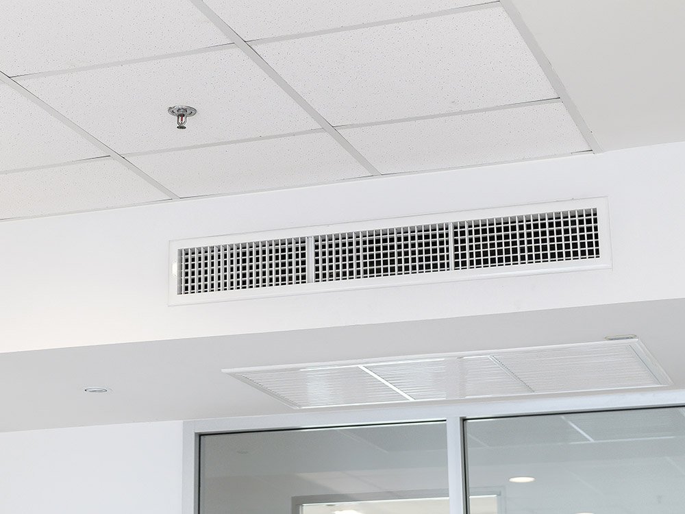 Raumlufttechnische Anlage mit Luftverteilung und Deckenintegration im Innenbereich Deckenlüftung mit Luftauslässen und Brandschutzsprinkler in einem Bürogebäude